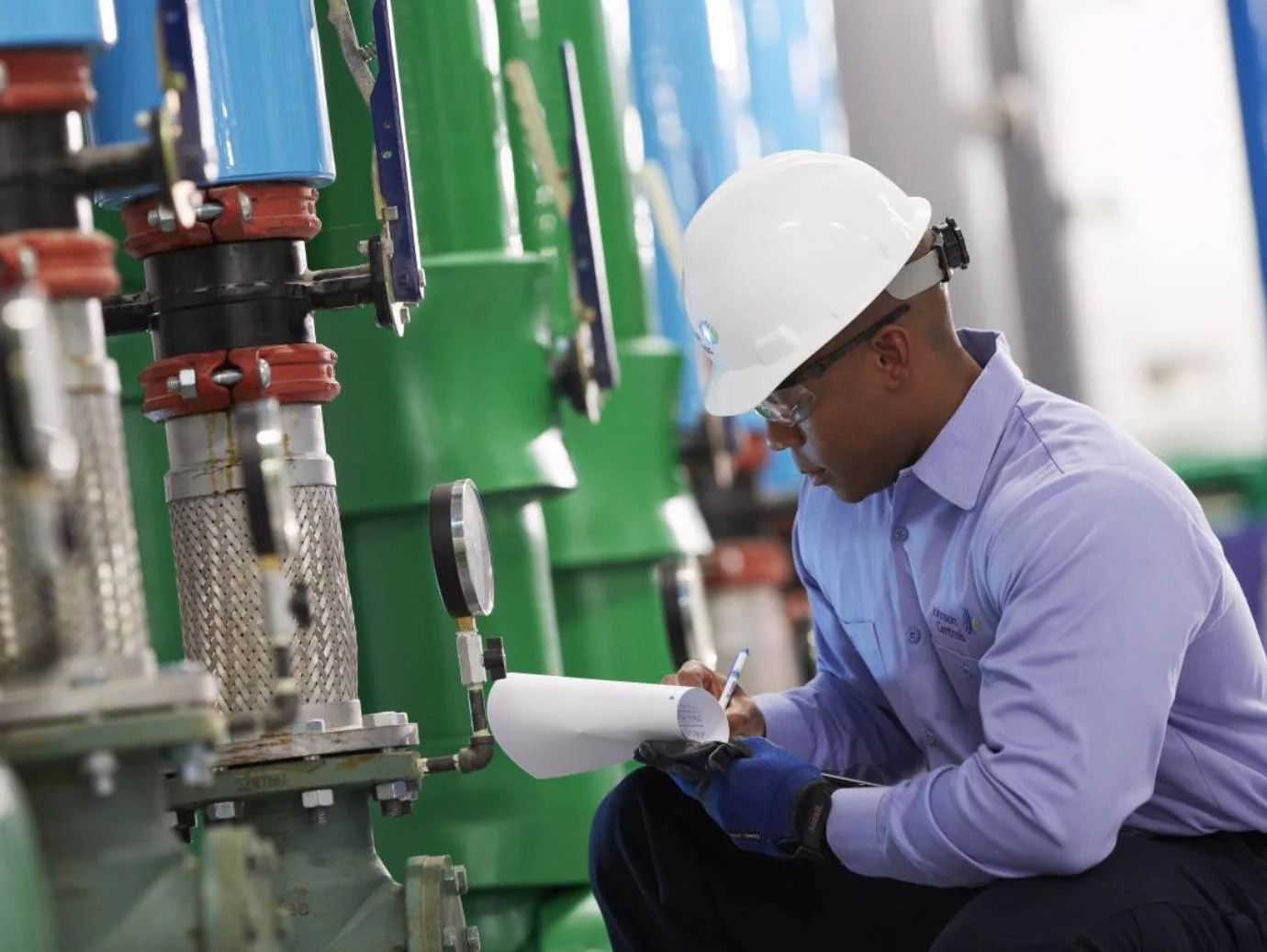 Mechanic recording equipment readings during a preventive inspection
